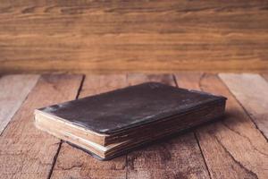 vieux livre cartonné sur table en bois. photo