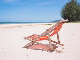 chaise en toile rouge sur la plage. photo