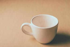 tasse blanche vide sur fond de table en bois. photo