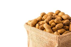 cacahuètes dans un sac de toile de jute sur fond blanc. photo