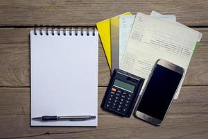 ordinateur portable avec smartphone et livre de comptes sur fond de bois, concept d'entreprise photo