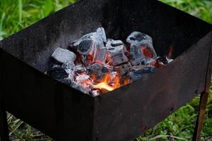 barbecue pour shish kebabs, charbons de barbecue, charbons de bouleau brûlent, charbon dans le gril. photo
