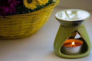 brûleur à mazout avec des chrysanthèmes à côté. brûleur d'aromathérapie. huile, brûleur d'aromathérapie, fleurs et bougies pour spa et détente. photo