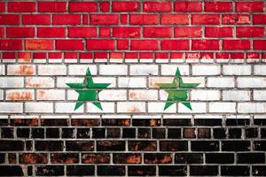 drapeau national de la syrie sur un fond de brique grunge. photo