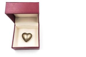 coeur doré dans une boîte cadeau rouge sur fond blanc. photo