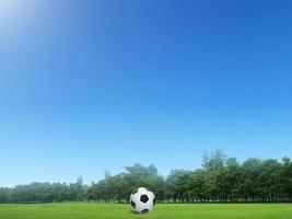 ballon de football sur l'herbe verte dans un beau parcours en thaïlande. ballon de football sur le parcours de ballon de football vert le matin avec la douce lumière du soleil photo