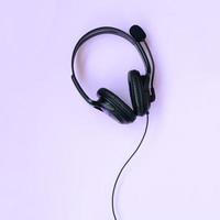 concept d'écoute de musique. casque noir se trouve sur fond violet photo
