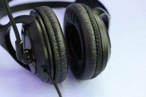 concept d'écoute de musique. casque noir se trouve sur fond violet photo