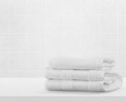 pile de serviettes propres blanches sur la table dans la salle de bain photo