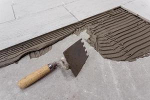 carreaux en céramique effet bois et outils pour carreleur au sol photo