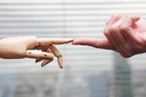 les mains humaines et en bois se touchent. intelligence artificielle, technologie et futur concept de progrès. photo