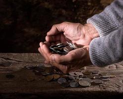 mains de l'homme caucasien et tas de vieilles pièces de monnaie