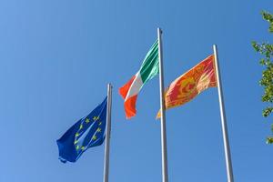 drapeau italien de l'ue et de la vénétie locale agitant dans le vent photo