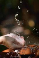 éclabousser de l'eau douce sur les mains de la femme photo