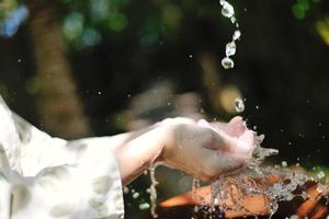 éclabousser de l'eau douce sur les mains de la femme photo