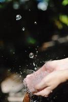 éclabousser de l'eau douce sur les mains de la femme photo