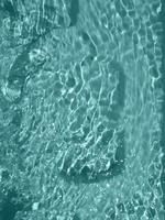 défocalisation floue transparente couleur bleue claire texture de surface de l'eau calme avec éclaboussures et bulle. fond de nature abstraite à la mode. vague d'eau au soleil avec espace de copie. texture aquarelle bleue photo