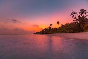 fantastique vue rapprochée des vagues d'eau de mer calme avec la lumière du soleil orange au coucher du soleil. paysage de plage de l'île tropicale, côte exotique. vacances d'été, vacances nature incroyable pittoresque. paradis de la détente photo