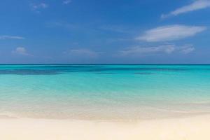 gros plan de sable sur la plage et ciel d'été bleu. paysage de plage panoramique. plage tropicale vide et paysage marin. ciel ensoleillé bleu pastel, sable doux, calme, lumière du soleil relaxante et tranquille, ambiance estivale photo