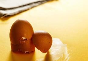 coquilles d'œufs sur une surface jaune et un morceau de sac en arrière-plan. vue rapprochée de la nourriture pour une vie saine. image horizontale. photo