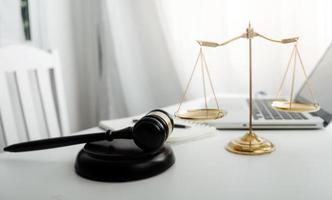 concept de justice et de droit. juge masculin dans une salle d'audience sur une table en bois et conseiller ou avocat masculin travaillant au bureau. concept de droit, de conseil et de justice juridique. photo