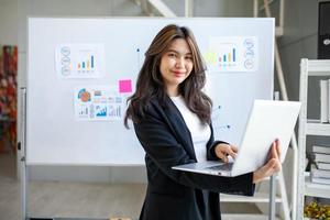 portrait d'une belle femme d'affaires asiatique travaillant au bureau, à l'aide d'un ordinateur. concept d'entreprise. photo