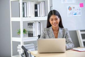 portrait d'une belle femme d'affaires asiatique travaillant au bureau, à l'aide d'un ordinateur. concept d'entreprise. photo