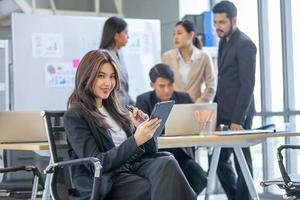 portrait d'une belle femme d'affaires asiatique travaillant au bureau, belle femme utilisant un pavé tactile avec le sourire sur le lieu de travail. photo