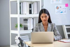 portrait d'une belle femme d'affaires asiatique travaillant au bureau, à l'aide d'un ordinateur. concept d'entreprise. photo