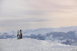 couple de snowboarders au sommet de la montagne photo