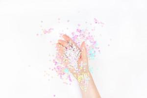 les confettis pastel perlés scintillent avec la main de la femme photo