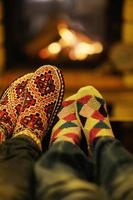 jeune couple romantique se détendre sur un canapé devant la cheminée à la maison photo