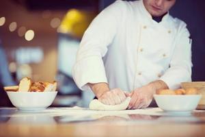 jeune chef préparant la pâte pour la pizza photo