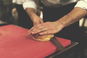 chef mains coupant des rouleaux pour burger photo