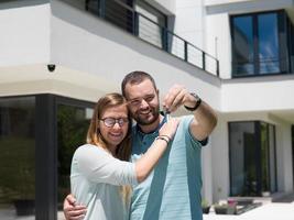 couple s'embrassant devant une nouvelle maison de luxe photo