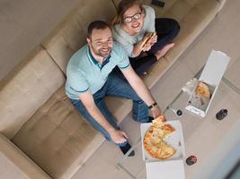 couple mangeant une pizza dans leur villa de luxe photo