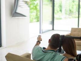 jeune couple sur le canapé devant la télévision photo