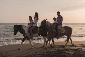 la famille passe du temps avec ses enfants tout en faisant de l'équitation ensemble sur une plage de sable. mise au point sélective photo