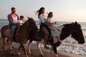 la famille passe du temps avec ses enfants tout en faisant de l'équitation ensemble sur une plage de sable. mise au point sélective photo