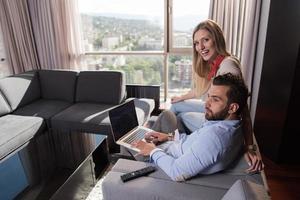 couple se détendant à la maison à l'aide d'ordinateurs portables photo
