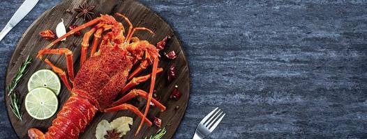 homard bouilli cuit, délicieux dîner repas de fruits de mer avec couteau et fourchette sur fond d'ardoise en pierre noire, conception de menus de restaurant, vue de dessus, frais généraux