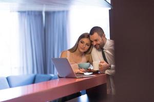 un jeune couple se prépare à un travail et utilise un ordinateur portable photo