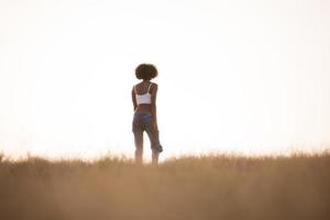 jeune fille noire danse à l'extérieur dans un pré photo