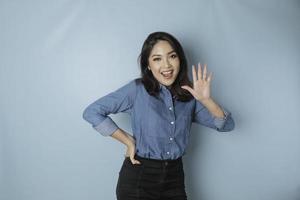 femme asiatique excitée portant une chemise bleue donnant le numéro 12345 par geste de la main photo