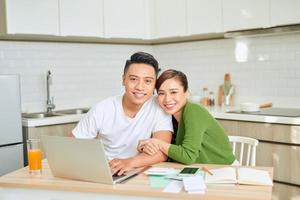 femme et homme faisant de la paperasse ensemble, payant des impôts en ligne sur un ordinateur portable photo