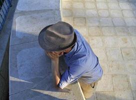 homme avec un feutre, la tête appuyée sur ses mains vu d'un angle élevé photo