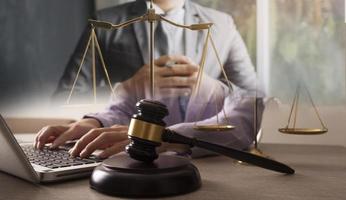 avocat masculin travaillant avec des documents contractuels et un marteau en bois sur table dans la salle d'audience. justice et droit, avocat, juge de la cour, concept. photo