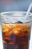 boisson gazeuse dans un verre avec des pailles sur une table dans un restaurant. avec arrière-plan flou photo