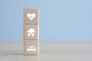 notion d'assurance. objectif et cible pour la meilleure vie ou protection contre une éventualité possible. icône de maison, de voiture et de santé sur un bloc de bois pour le concept de vie d'assurance. photo