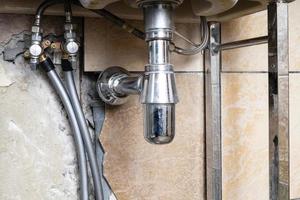 conduites d'eau reliées à la valve du lavabo dans la salle de bain photo